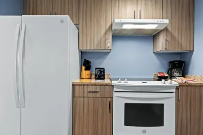 a kitchen with a white refrigerator and wooden cabinets at WorldMark Victoria in Victoria