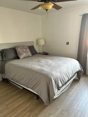 a bedroom with a large bed with a ceiling fan at Sonora Desert Inn in Osoyoos