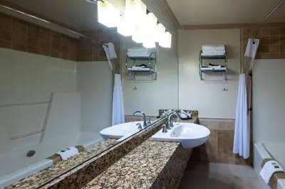 a bathroom with two sinks and a tub at Kaslo Hotel in Kaslo