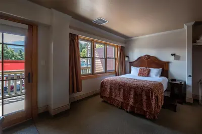a hotel room with a bed and a balcony at Kaslo Hotel in Kaslo