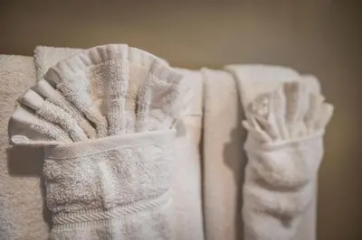 a group of white towels stacked on top of each other at The Hidden Hollow Suite - Downtown in Drumheller
