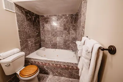 a bathroom with a toilet and a bath tub at The Watermark Suite - Downtown in Drumheller