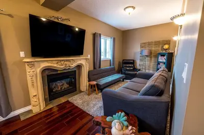 a living room with a tv and a fireplace at The River Blossom Suite - Downtown in Drumheller