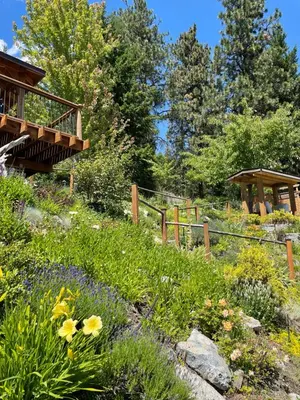 a garden with flowers and a wooden fence at Les Chambres Roses in West Kelowna
