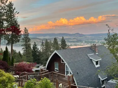 a house with a deck on top of it at Les Chambres Roses in West Kelowna