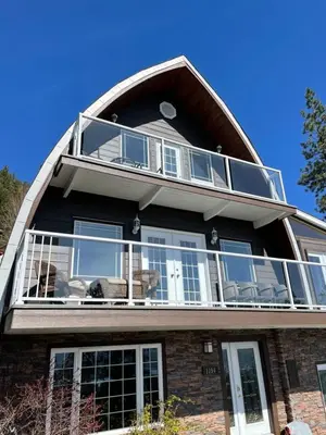 a large house with a large balcony on top of it at Les Chambres Roses in West Kelowna