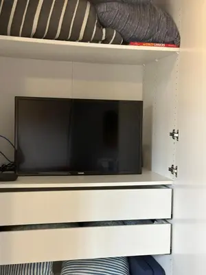 a flat screen tv sitting on top of a shelf at K STREET CARRIAGE HOUSE Studio in Penticton