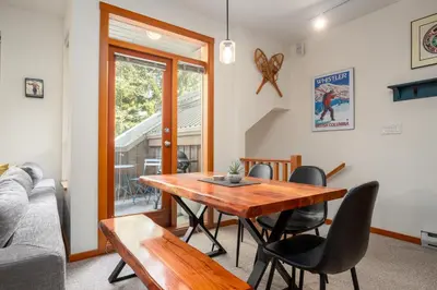 a living room with a wooden table and chairs at 2BR in Symphony, Dog Friendly, Hot Tub, Private Balconies, Village Location, Parking in Whistler