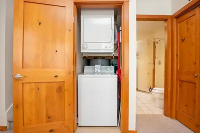a kitchen with a refrigerator and a tv on top of it at 2BR in Symphony, Dog Friendly, Hot Tub, Private Balconies, Village Location, Parking in Whistler
