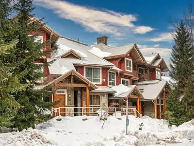 a large house with snow on the ground at 2BR in Symphony, Dog Friendly, Hot Tub, Private Balconies, Village Location, Parking in Whistler