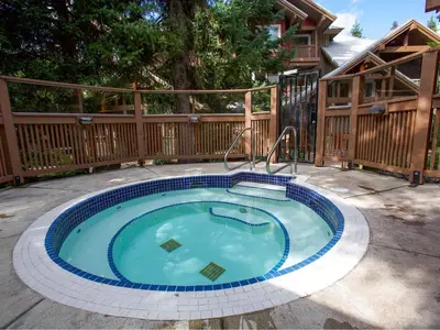 a swimming pool in a backyard with a wooden fence at 2BR in Symphony, Dog Friendly, Hot Tub, Private Balconies, Village Location, Parking in Whistler