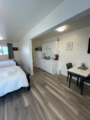 a bedroom with a bed and a table and a kitchen at Destination INN in Radium Hot Springs