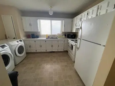 a kitchen with a refrigerator and a washer and dryer at MT Pleasant NW 2 bedrooms 502 in Calgary