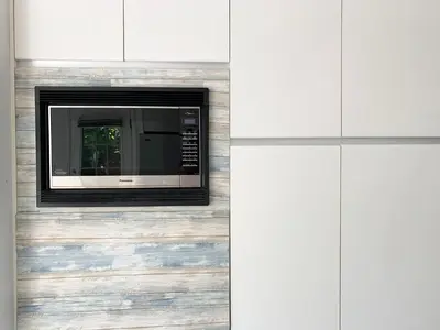 a microwave oven mounted on a wall in a kitchen at One Bedroom queen bed Sharing Washroom in Tiger Sweet House License## in Richmond
