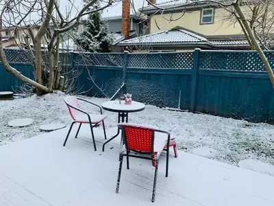two chairs and a table in the snow at One Bedroom queen bed Sharing Washroom in Tiger Sweet House License## in Richmond