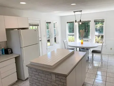 a kitchen with a white refrigerator and a table at One Bedroom queen bed Sharing Washroom in Tiger Sweet House License## in Richmond