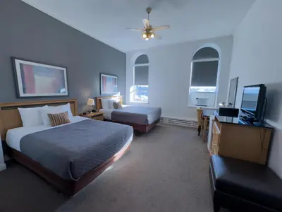 a bedroom with two beds and a flat screen tv at The Met Hotel in New Westminster