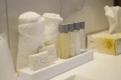 a shelf with four bottles of toilet paper and towels at The Met Hotel in New Westminster