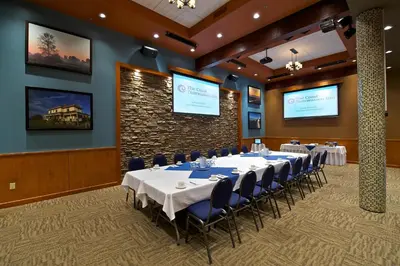 a conference room with tables and chairs and screens at Coast Tsawwassen Inn in Delta