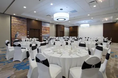a conference room with white tables and white chairs at Coast Tsawwassen Inn in Delta