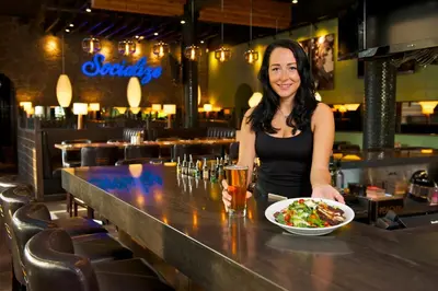 a woman sitting at a bar with a bowl of food at Coast Tsawwassen Inn in Delta