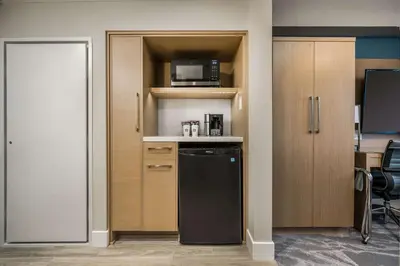 a kitchen with a black refrigerator and a microwave at Coast Tsawwassen Inn in Delta