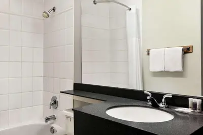 a bathroom with a sink and a toilet and a tub at Days Inn by Wyndham Vancouver Downtown in Vancouver