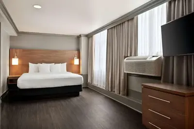 a hotel room with a bed and a television at Days Inn by Wyndham Vancouver Downtown in Vancouver