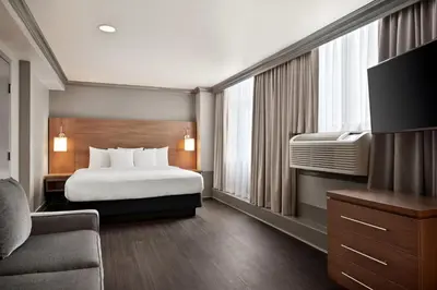 a hotel room with a bed and a television at Days Inn by Wyndham Vancouver Downtown in Vancouver
