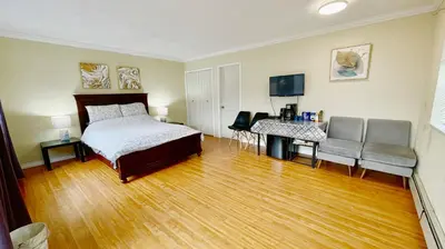 a bedroom with a bed and a wooden floor at Private Suite with Separated Entrance Monica's Home in Richmond