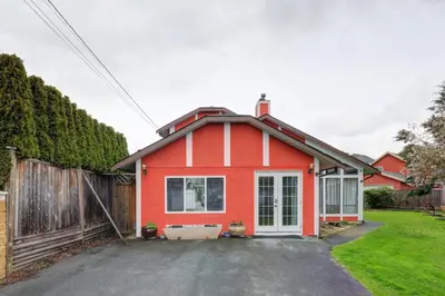 a red house with a fence in a yard at Private Suite with Separated Entrance Monica's Home in Richmond