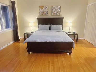 a bedroom with a large bed with two end tables at Private Suite with Separated Entrance Monica's Home in Richmond