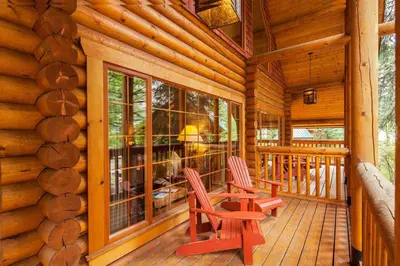 two chairs on a porch of a log cabin at Cathedral Mountain Lodge in Field