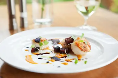 a plate of food on a table with a glass of wine at Cathedral Mountain Lodge in Field