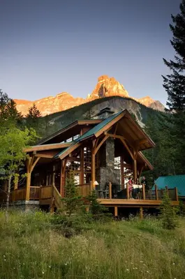 a large log cabin with a mountain in the background at Cathedral Mountain Lodge in Field