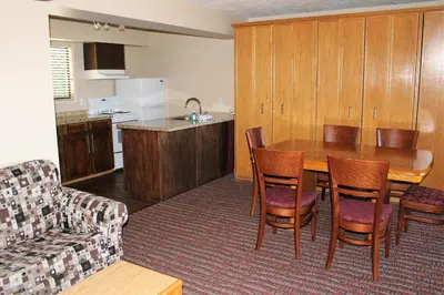 a kitchen with a table and chairs and a couch at Ramada by Wyndham Campbell River in Campbell River