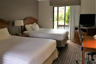 a hotel room with two beds and a television at Ramada by Wyndham Campbell River in Campbell River