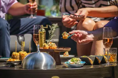 a group of people sitting around a table with food at The Parker Hotel and Rooftop in Vancouver