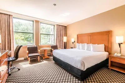 a hotel room with a bed and a desk at The Sylvia Hotel in Vancouver