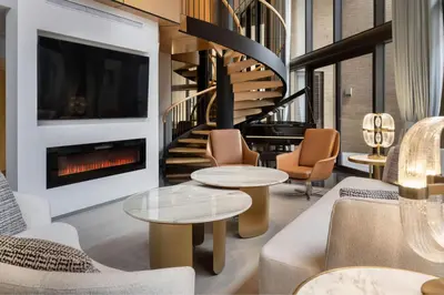 a living room with two tables and a fireplace at Metropolitan Hotel Vancouver in Vancouver