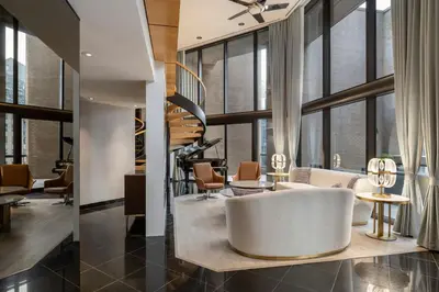a lobby with a white couch and chairs and windows at Metropolitan Hotel Vancouver in Vancouver