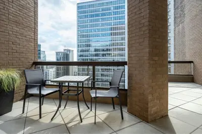 a table and chairs on a balcony with a view at Metropolitan Hotel Vancouver in Vancouver