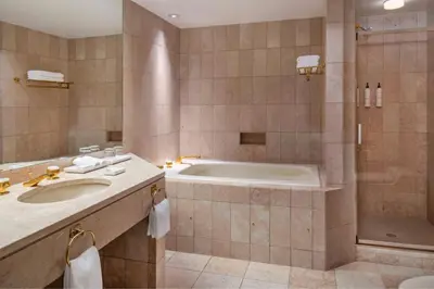 a bathroom with a tub and a sink and a shower at Metropolitan Hotel Vancouver in Vancouver