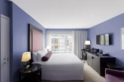 a hotel room with a white bed and a window at OPUS Vancouver in Vancouver