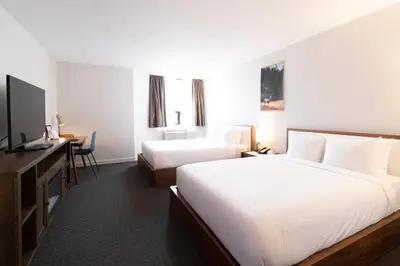 a hotel room with two beds and a television at Adara Hotel in Whistler