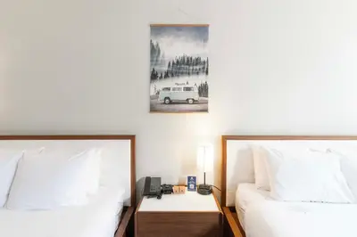 a bedroom with two beds and a picture of a car at Adara Hotel in Whistler