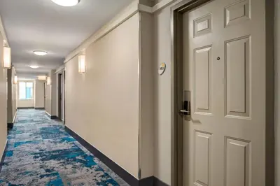 a hallway with a door and blue carpet at La Quinta Inn by Wyndham Vancouver Airport in Richmond