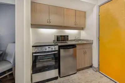 a small kitchen with a stove and a sink at Days Inn by Wyndham Victoria On The Harbour in Victoria