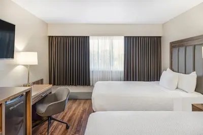 a hotel room with a bed and a desk at Days Inn by Wyndham Victoria On The Harbour in Victoria