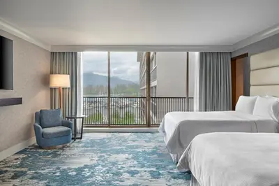 a hotel room with two beds and a balcony at The Westin Bayshore, Vancouver in Vancouver